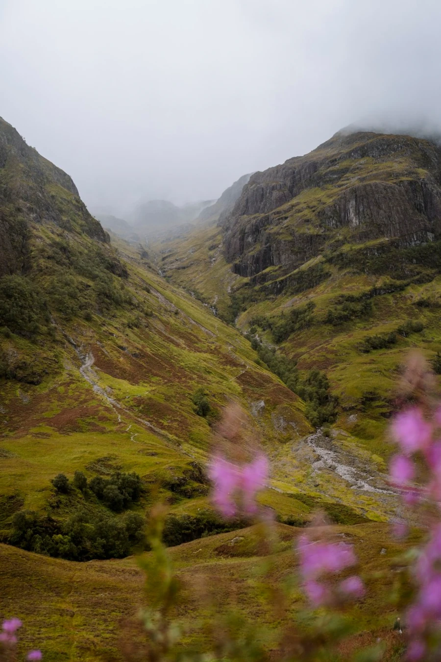 In the distance a small trail follows a steep incline into the mountains leading to Lost Valley (Coire Gabhail) near Glencoe, Scotland.