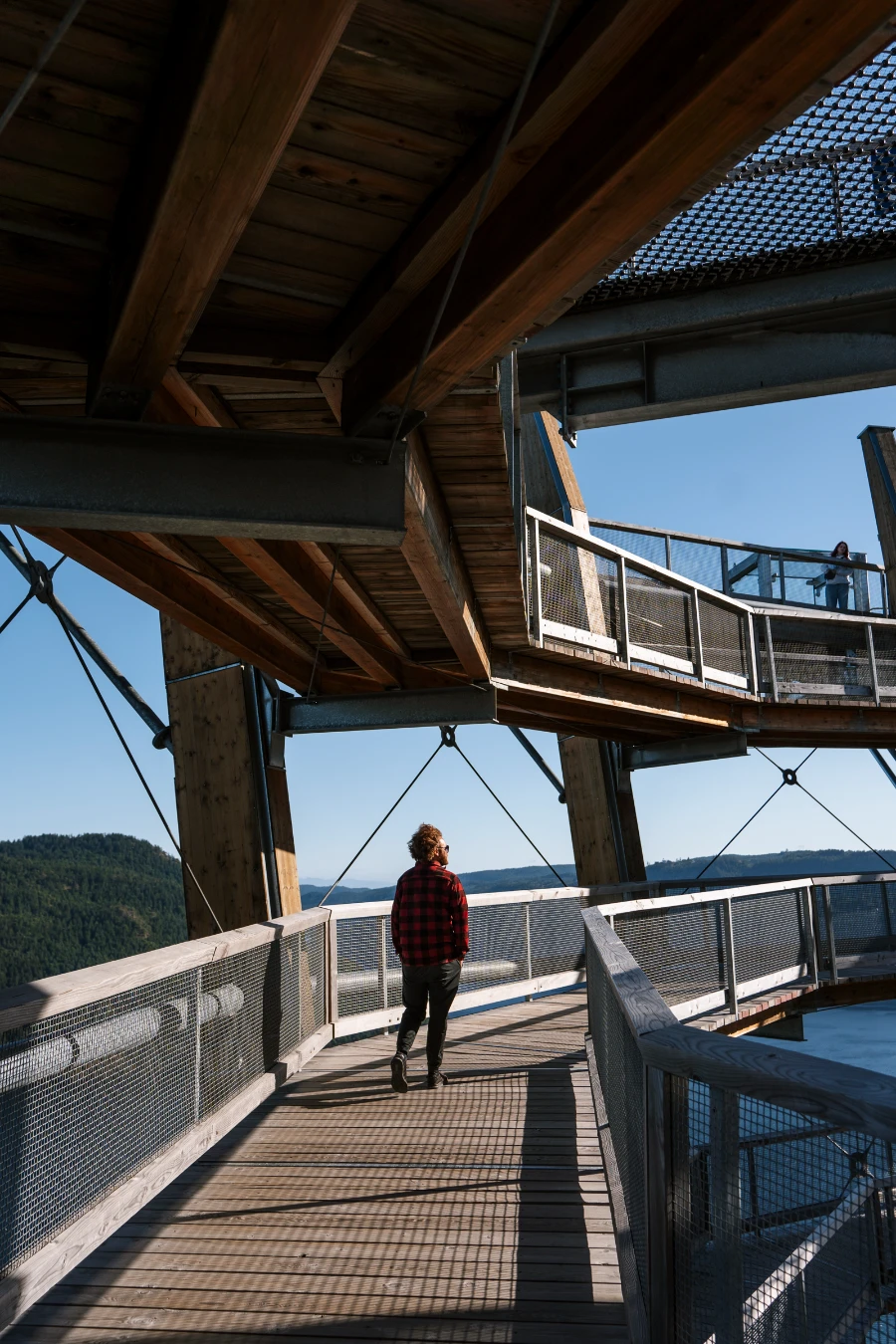 A man walking along a spiral boardwalk on the Malahat Skywalk in Cowichan Valley