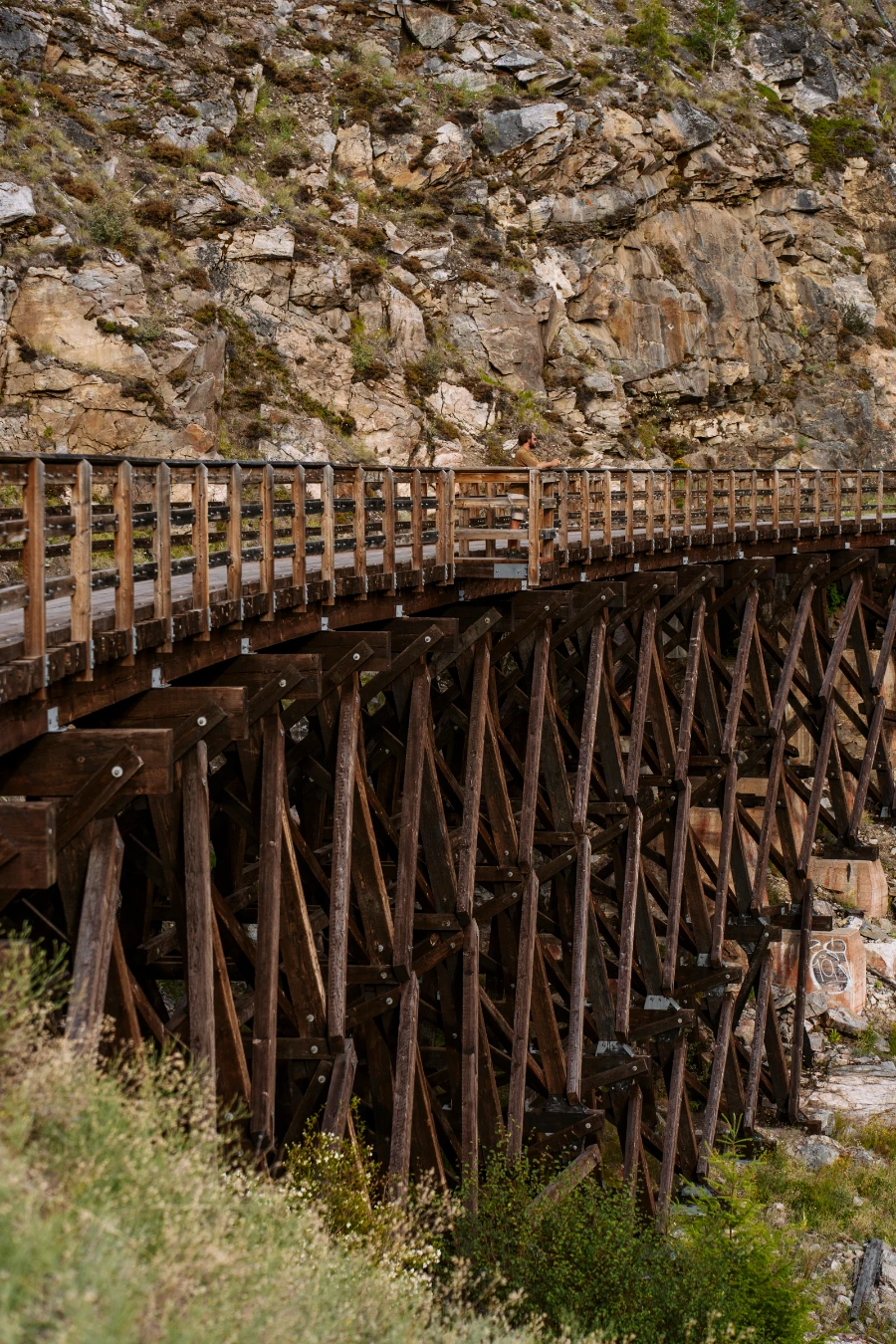 A man stands in the centre of a massive wooden trestle that connects two parts of a trail cutting through Myra Canyon just outside of Kelowna
