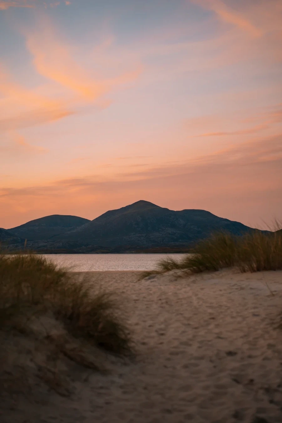 A sandy path leads down to the beach at sunset on The Isle of Harris