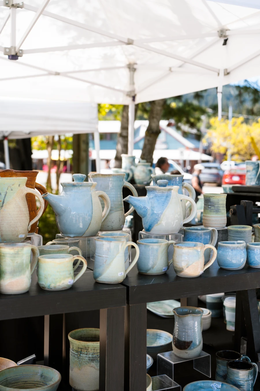 A collection of handmade ceramics set up on display at the Salt Spring Island farmers market