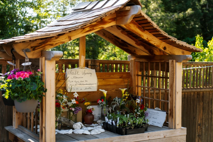 A collection of flowers for sale set up on an ornate wooden stand on the side of the road near Fulford Harbour on Salt Spring Island