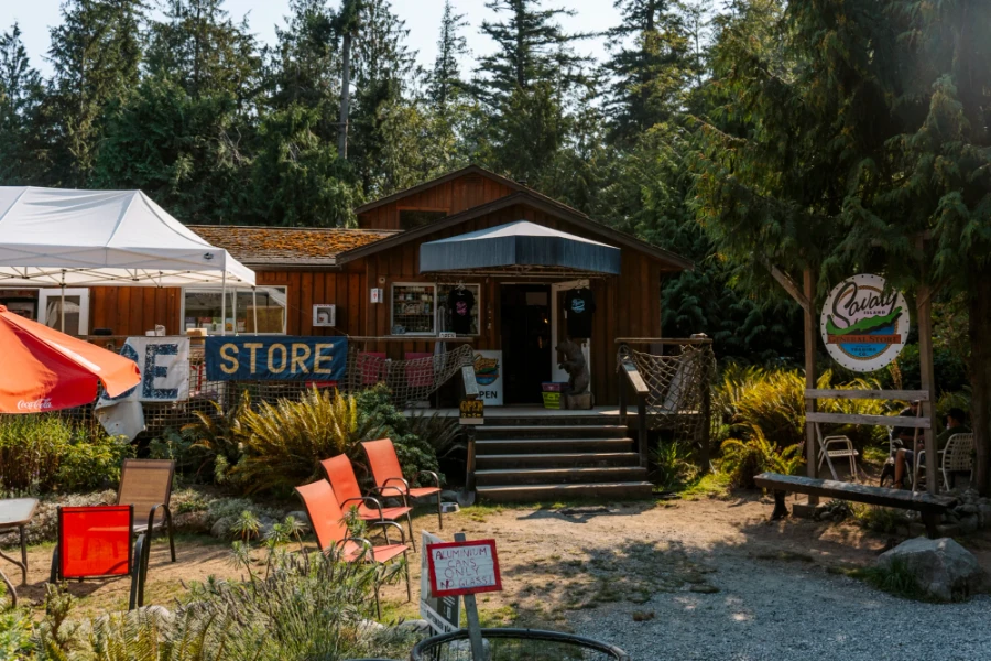 The facade of the Savary Island General Store with lawn chairs in the front yard in the sun