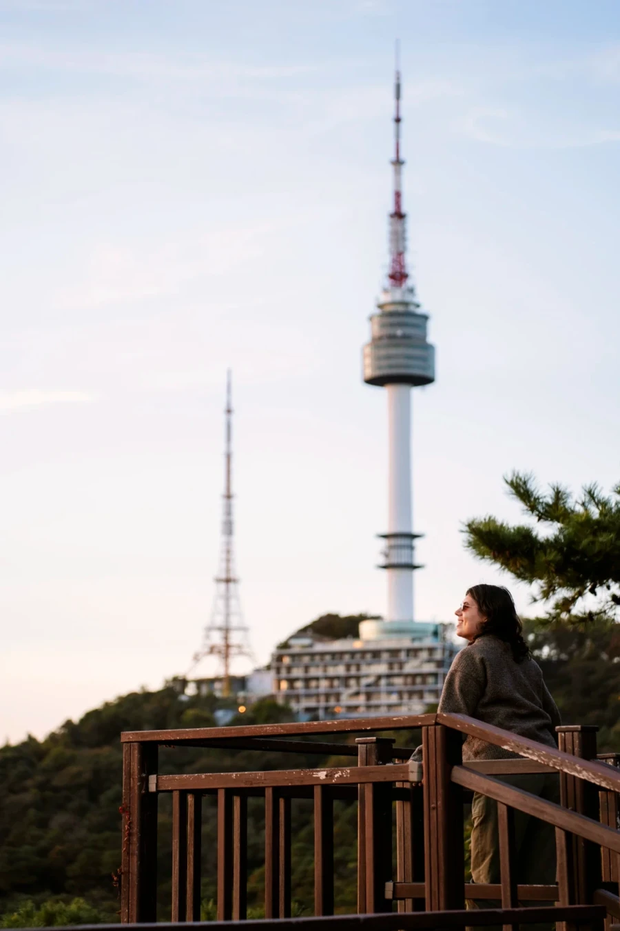 Woman standing on a wooden lookout with N Seoul Tower behind her