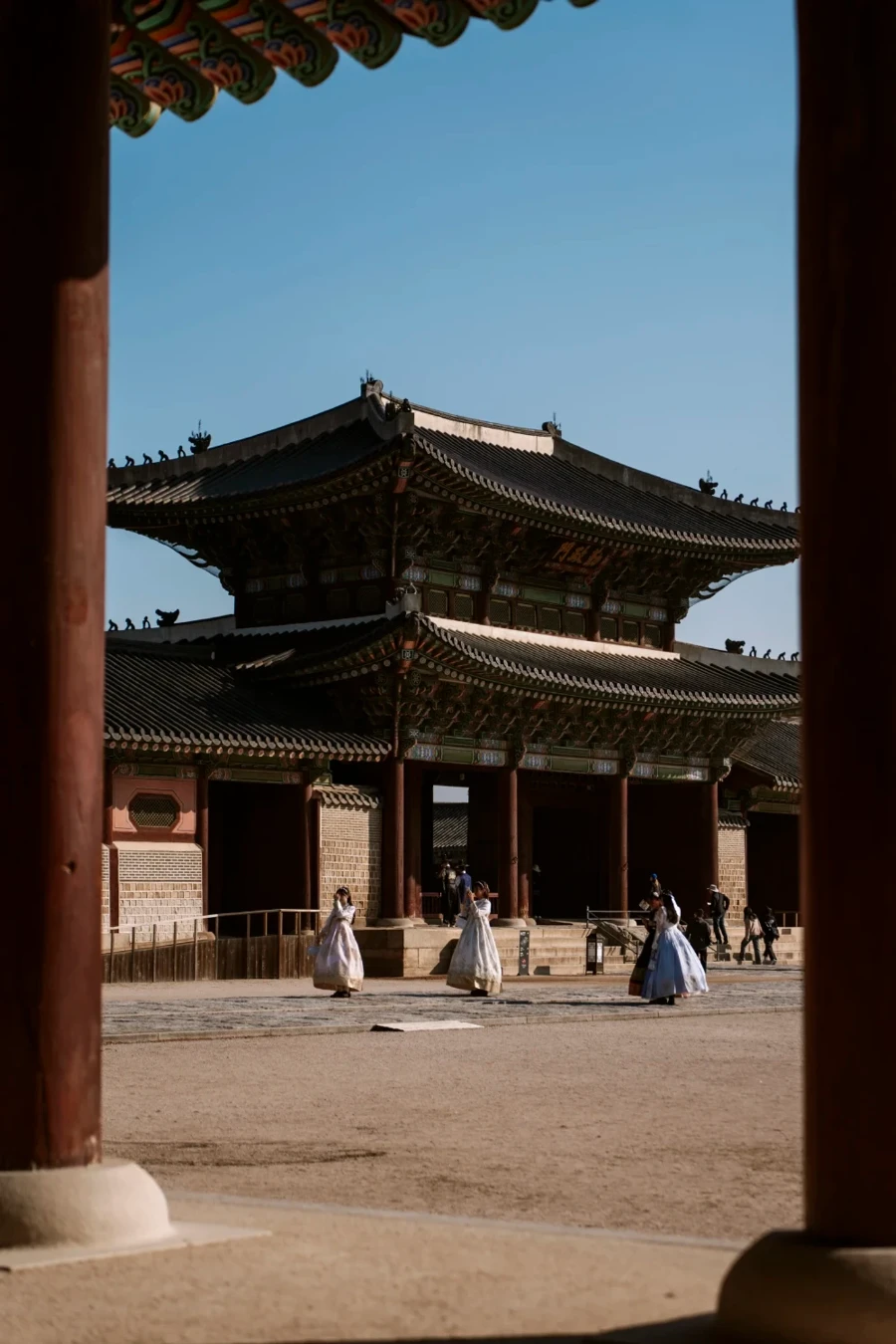 Women wearing traditional dresses taking photos at Gyeongbokgung Palace