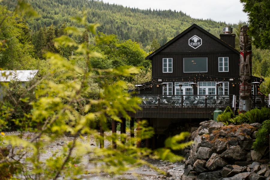 A large wooden pub on the shore at low tide in Port Renfrew