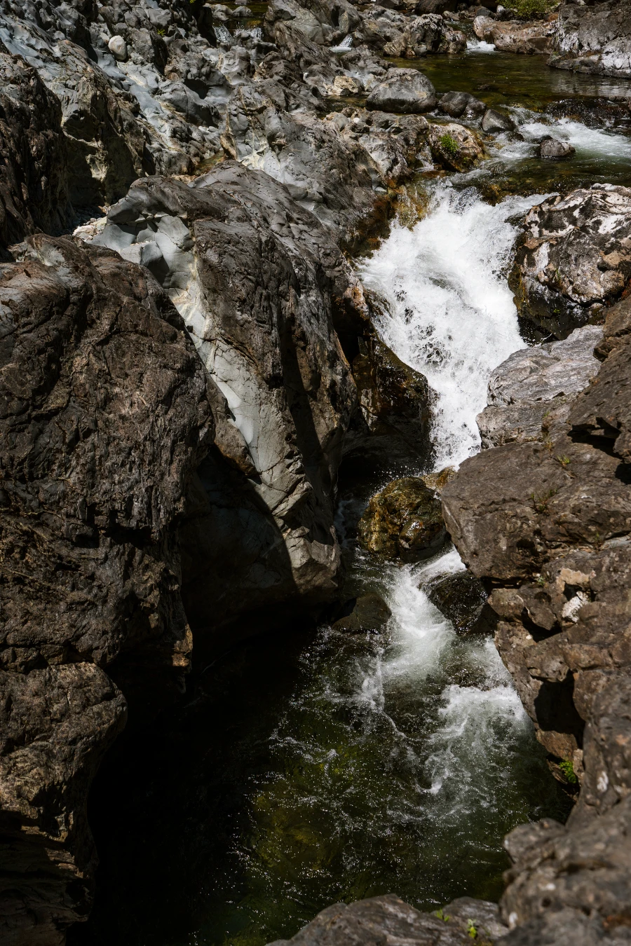 A powerful waterfall pours into a deep and narrow canyon in Sooke Potholes Provincial Park