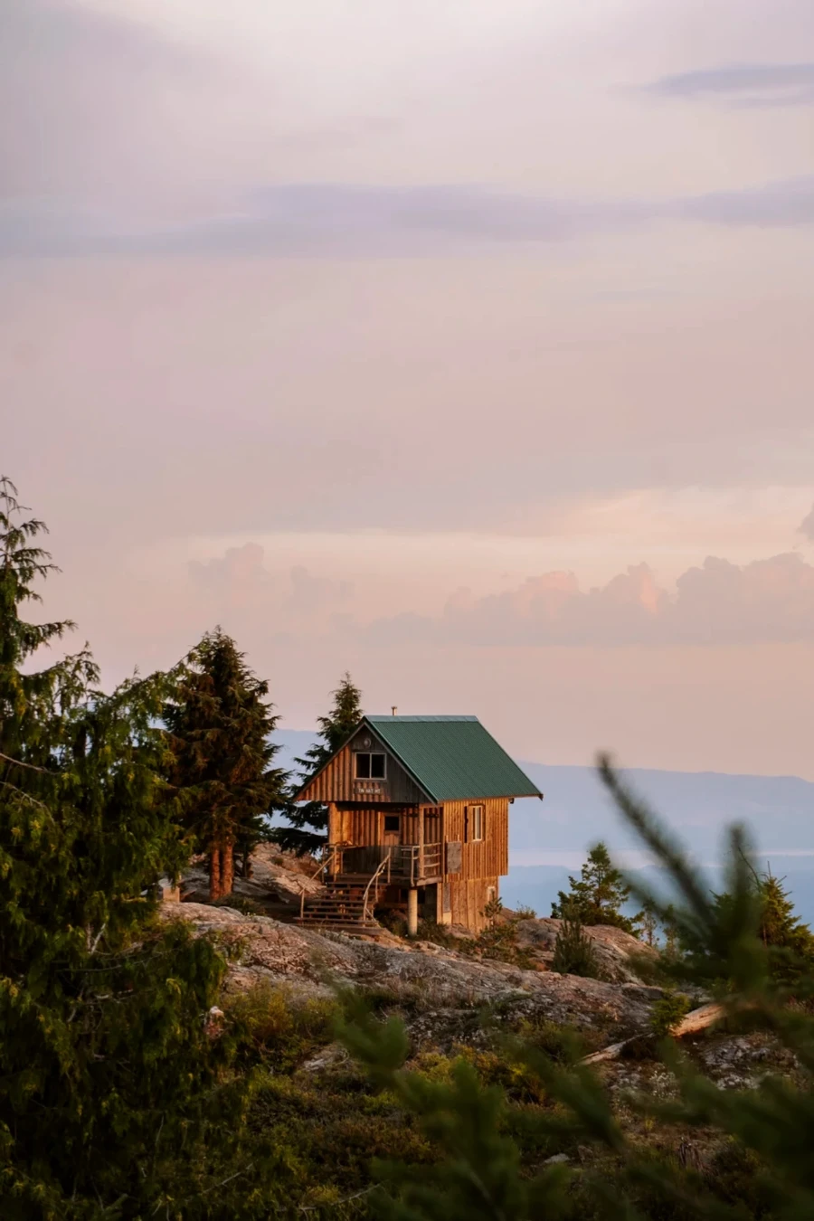 A wooden hut on the edge of a cliff at sunset