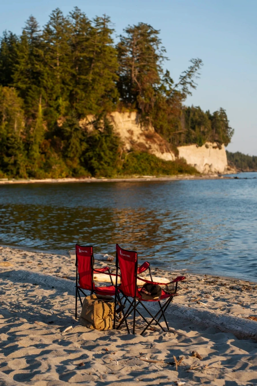 Two red camp chairs set up in the sand at Buccaneer Bay on Thormanby Island