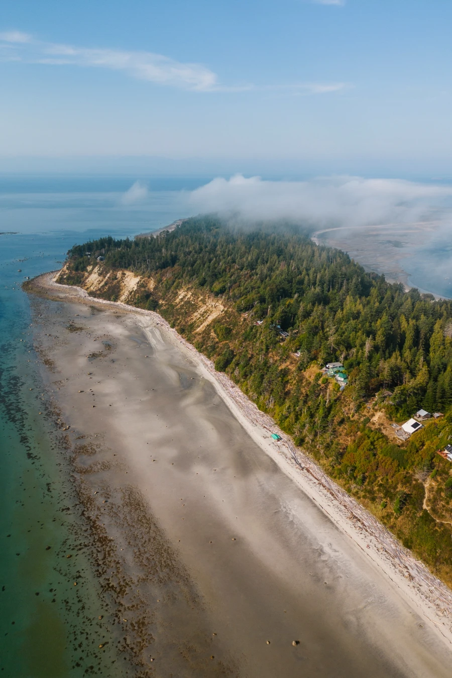 A long sandy beach lined with massive sand stone cliffs