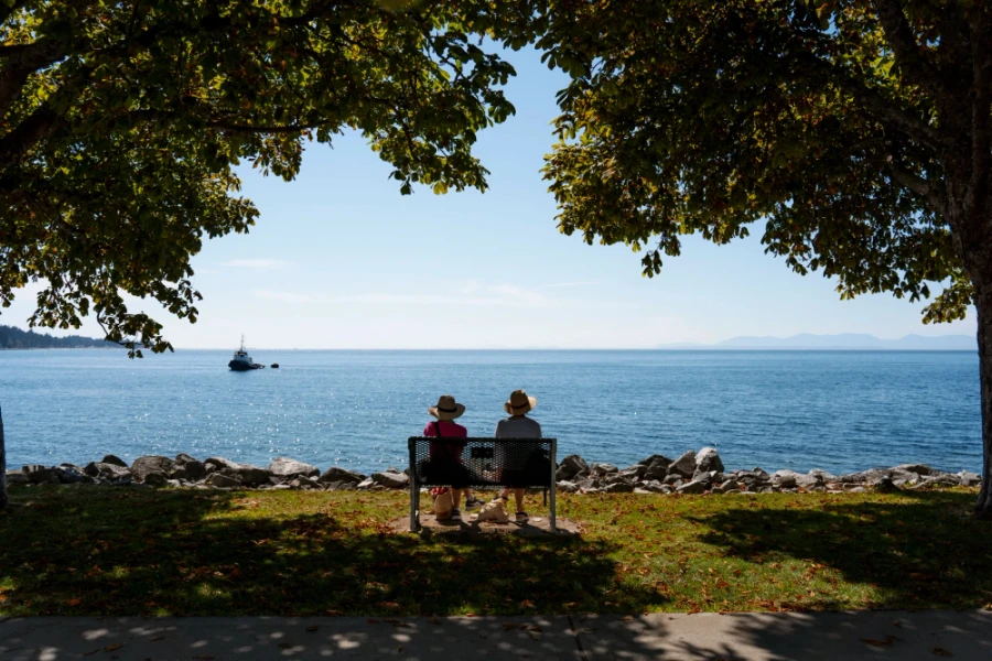 two people sitting on a bench along the Sechelt Waterfront Promenade