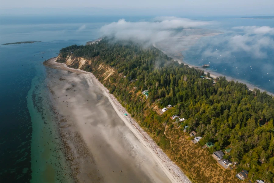 A long white sand beach bordered by limestone cliffs at low tide