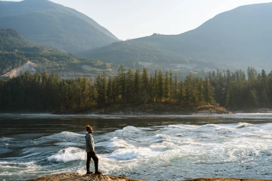 man stands on the shore in front of the Skookumchuck Rapids