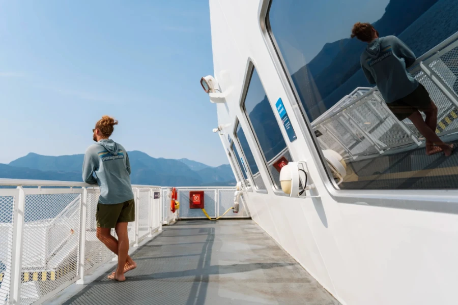 man leaning on the railing of a a BC ferry looking out to the Sunshine Coat