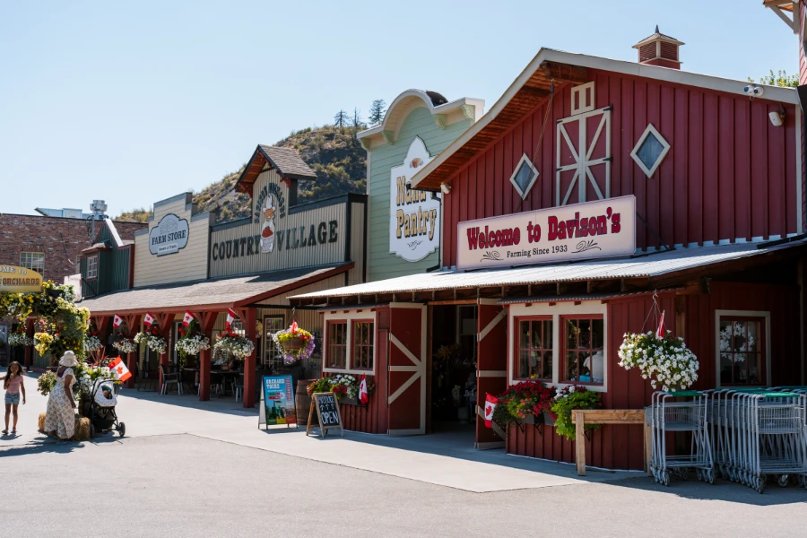 A large open area in front of a line of shops that are all vaguely farm themed