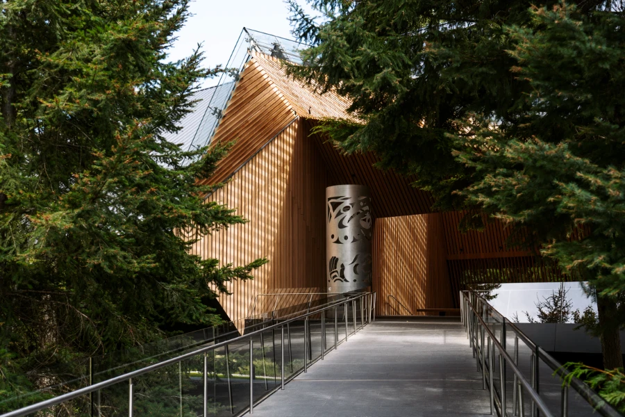 A cement ramp lined with stainless steel railings leads up to the unique wooden architecture of the Audain Art Museum
