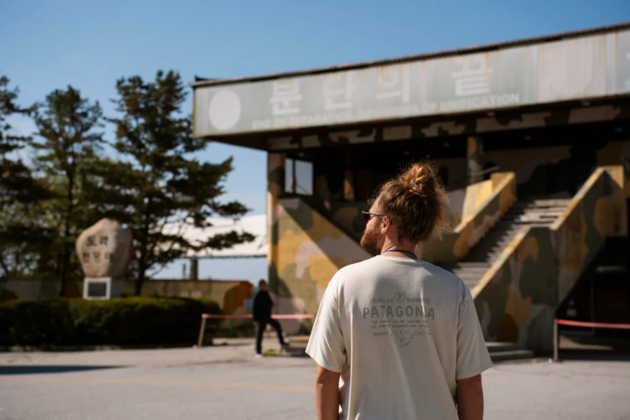 Man standing in front of a deserted building and the South and North Korean border
