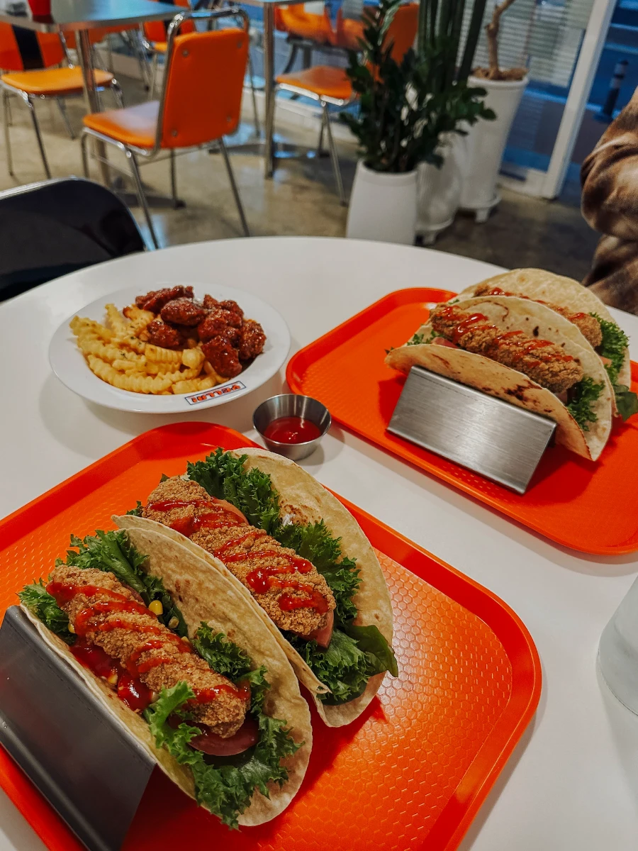two red lunch trays hold several tacos
