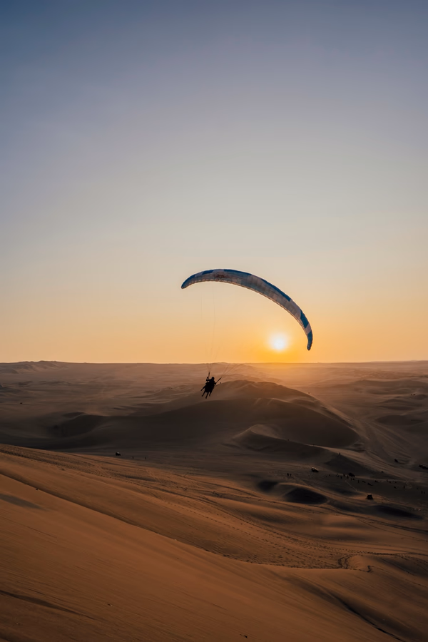 Best Things to Do In Huacachina, Peru: paragliders in the sky above Huacachina