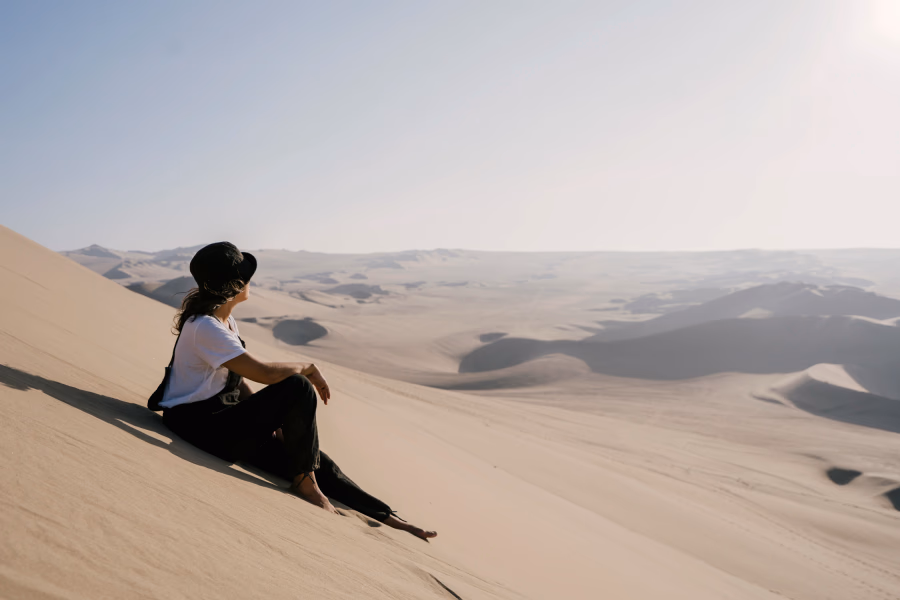 Best Things to Do In Huacachina, Peru: woman looks out on a sea of sand dunes