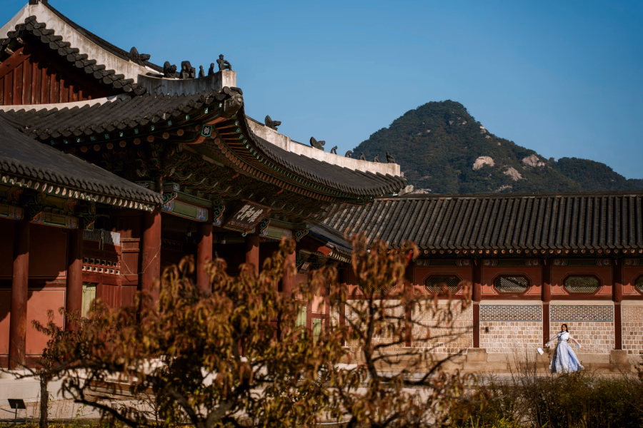 Woman in a traditional hanbok dress twirls in the courtyard of Gyeongbokgung Palace