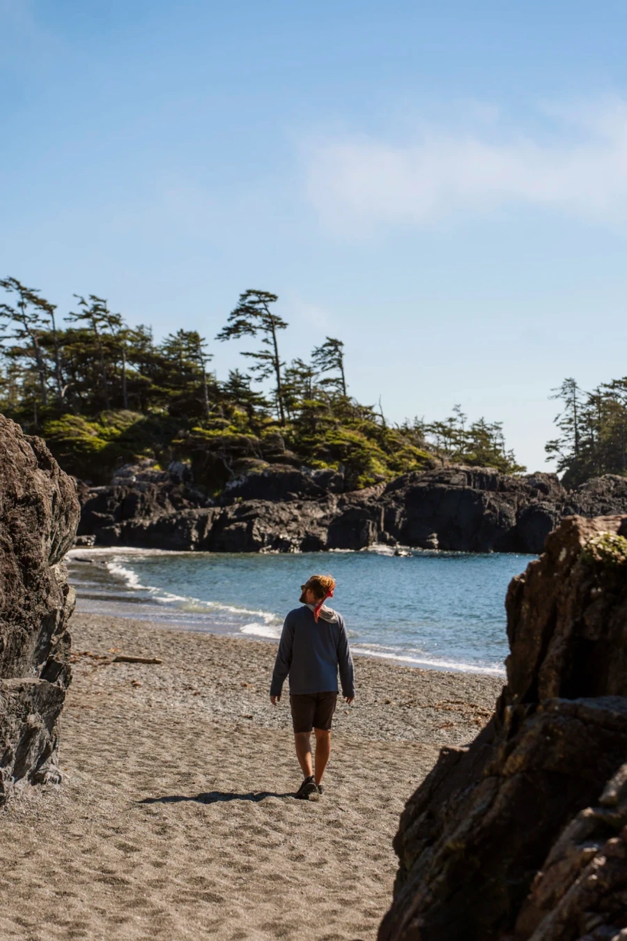 A man walking along the sand at South Beach in Tofino