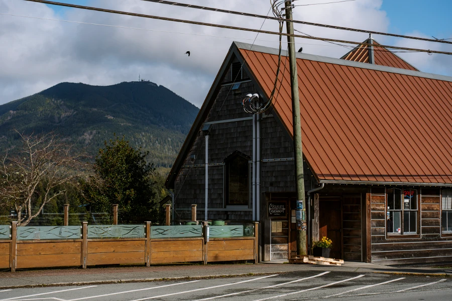 A tin roofed wooden building with a large patio on the side of a road in Ucluelet, BC