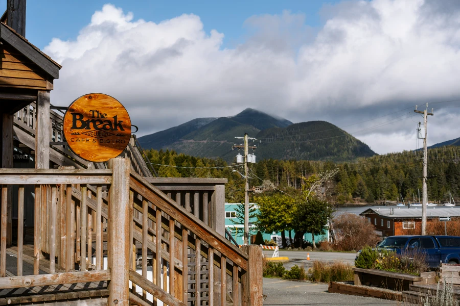 A sign at the top of a set of wooden stairs reads The Break Cafe & Bistro in Ucluelet, BC