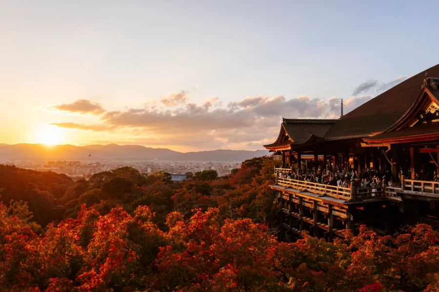 The sun sets on a sea of red fall foliage near Kiyomizu-dera