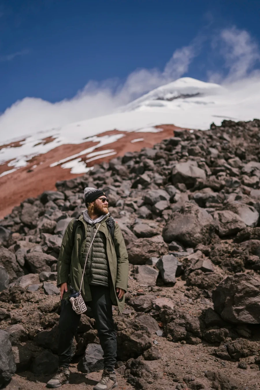 A man standing among a pile of loose rocks on Cotopaxi Valcano