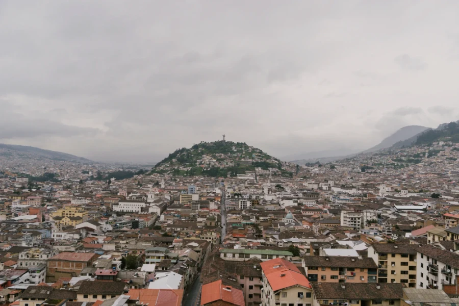 A sea of buildings surround a hill with El Panecillo at the top