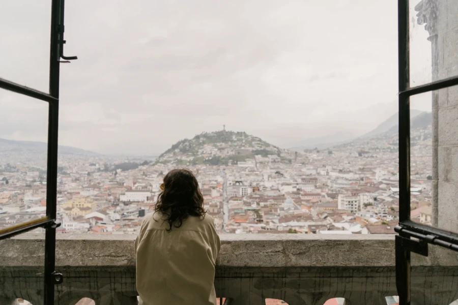 Woman looking out a window to El Panecillo