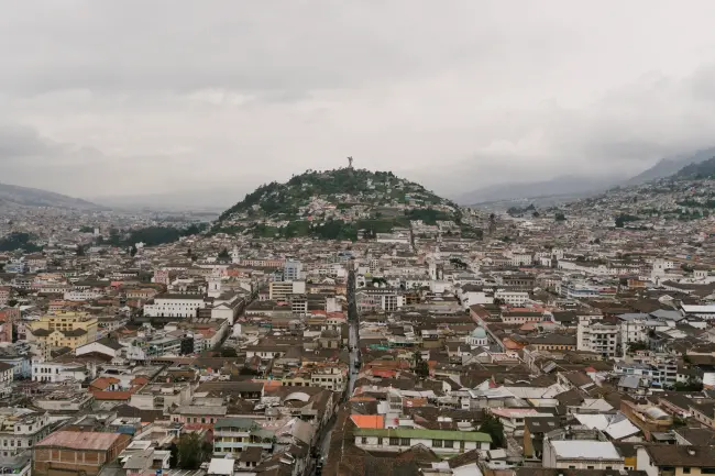 A sea of buildings surround a large hill in Quito, Ecuador