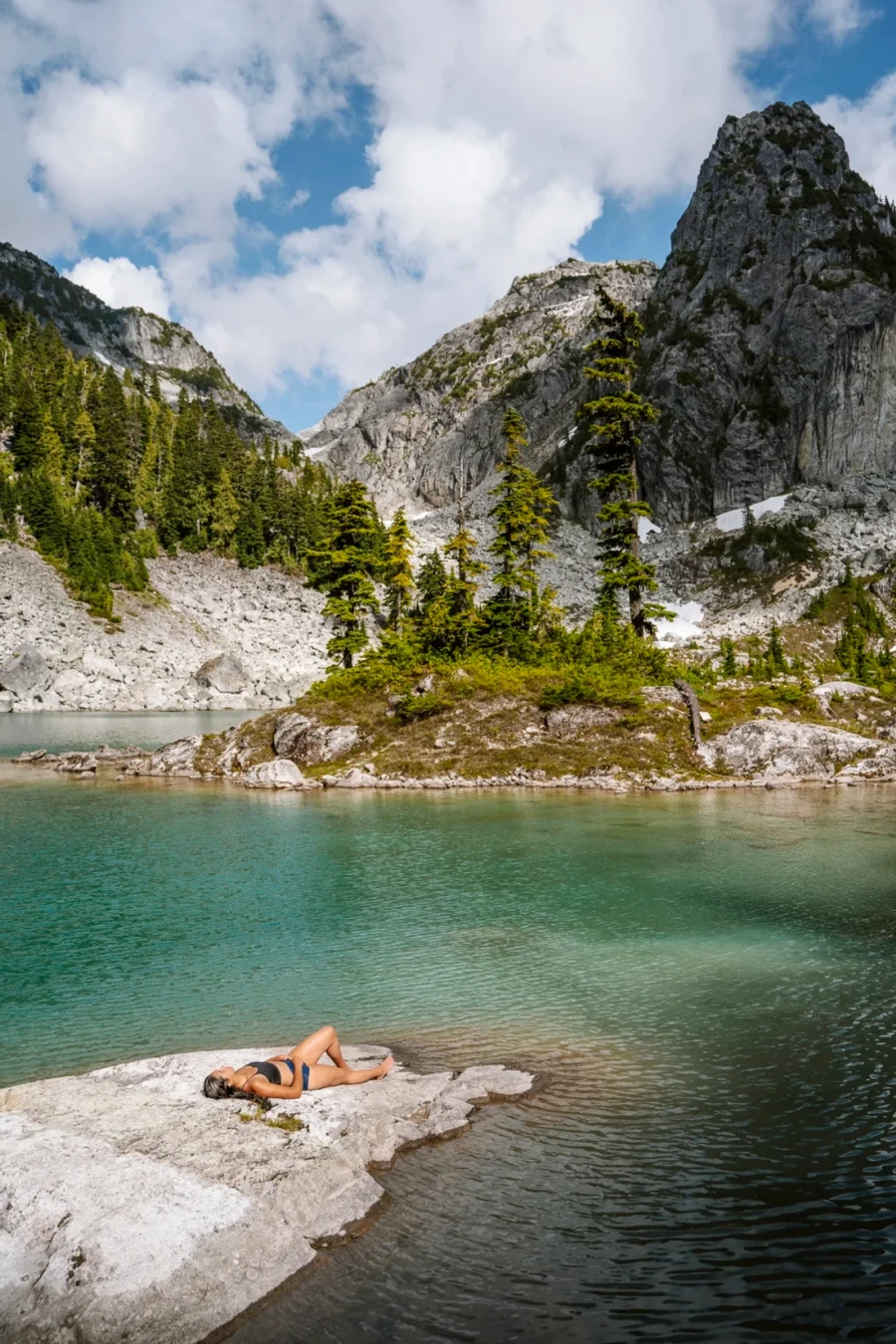 woman laying out drying in the sun on a rock at the edge of Watersprite Lake