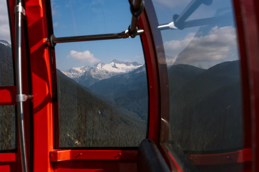 Distant glacier covered peaks framed through the window of a gondola